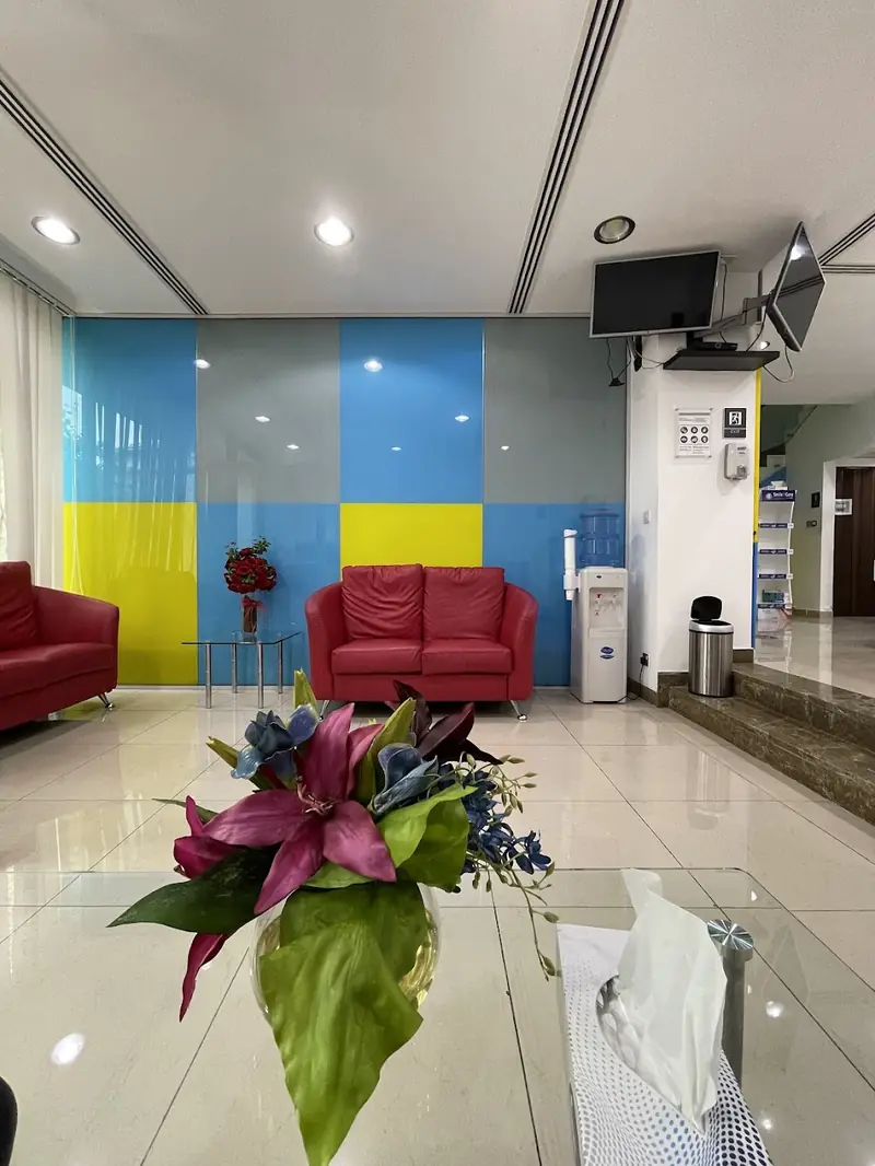 Waiting area with the cyan and yellow wall and fresh flowers